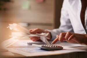 man using calculator to pay tax bills